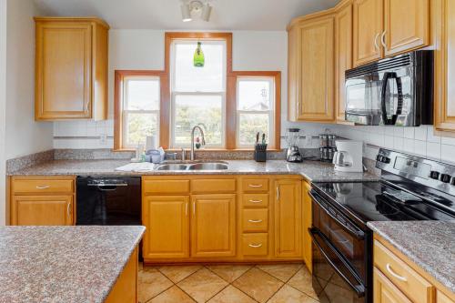 a kitchen with wooden cabinets and a sink at Devon's Landing #3-PA in Avon
