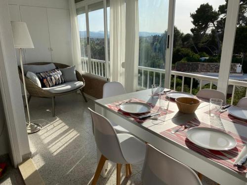 een eetkamer met een tafel en stoelen en een balkon bij Apartamento RosarioyEmma - Primera línea de playa con vista mar in Jávea