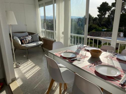 une salle à manger avec une table et des chaises et un balcon dans l'établissement Apartamento RosarioyEmma - Primera línea de playa con vista mar, à Jávea