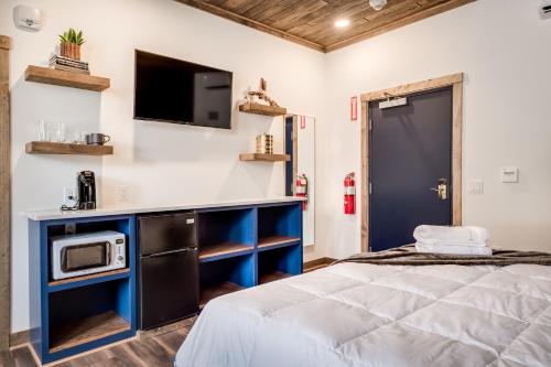 a bedroom with a bed and a tv on the wall at The Port of Prescott Boutique Hotel in Prescott