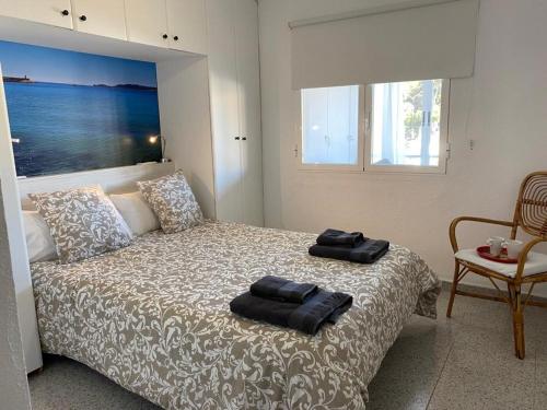 een slaapkamer met een bed met twee handdoeken erop bij Apartamento RosarioyEmma - Primera línea de playa con vista mar in Jávea