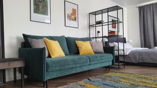 a living room with a green couch with yellow pillows at Central Apartments Апартаменти в центрі in Khmelnytskyi
