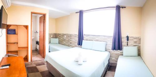a bedroom with two beds and a window at Pousada Solarium UNIDADE 1 ECONOMICA-BÁSICA in Guarujá