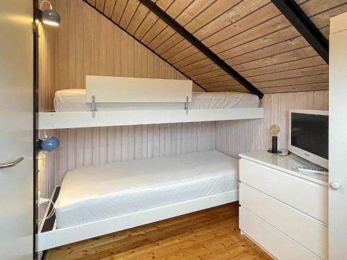 オテルプにあるThree-Bedroom Holiday home in Otterup 9の二段ベッドとテレビが備わる小さな客室です。