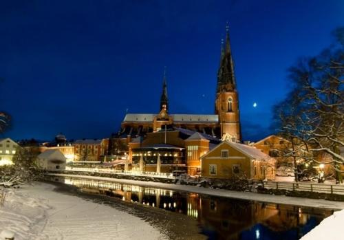 a large building with a clock tower at night at Uppsala City Hostel in Uppsala