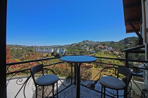 a balcony with two chairs and a table with a view at Casablanca Hotel Boutique in Campos do Jordão