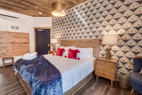 a bedroom with a large bed with red pillows at The Port of Prescott Boutique Hotel in Prescott