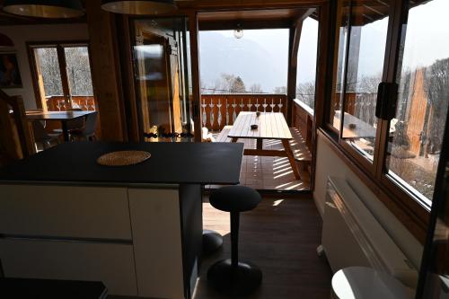 Cette chambre dispose d'un balcon avec une table et des fenêtres. dans l'établissement Chalet du Meilly, à Saint-Gervais-les-Bains