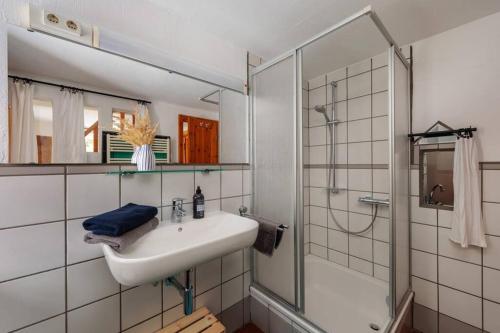a white bathroom with a sink and a shower at Ferienwohnung Kuschelzeit mit Sauna in Hohen Pritz