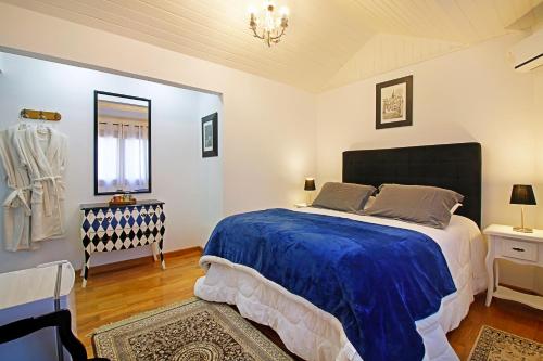 a bedroom with a large bed with a blue blanket at Casablanca Hotel Boutique in Campos do Jordão