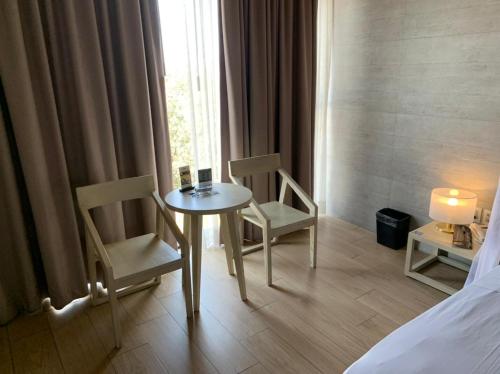a room with a table and chairs and a bed at Motel Okura Villas y Suites in Guadalajara
