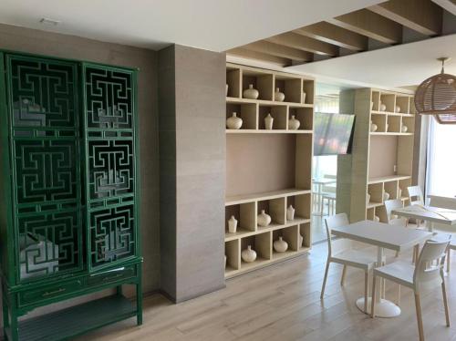 a dining room with a green door and a table and chairs at Motel Okura Villas y Suites in Guadalajara