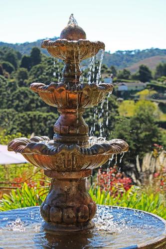 a stone fountain with water coming out of it at Casablanca Hotel Boutique in Campos do Jordão