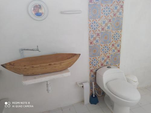 a bathroom with a wooden sink and a toilet at Los Versos de Zaira in San Onofre