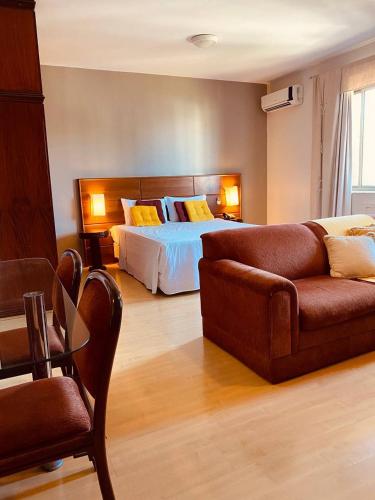 salon z łóżkiem i kanapą w obiekcie Apart-hotel, piscina, TV a cabo, academia w mieście Joinville