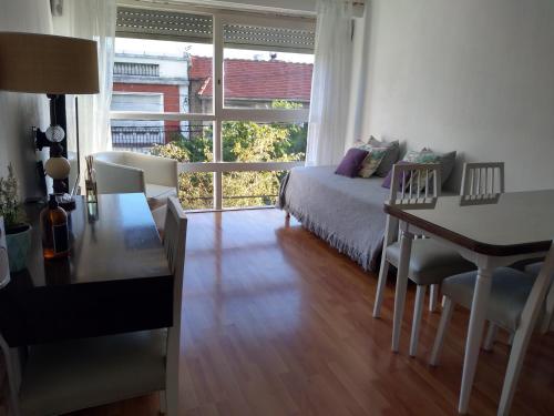 a bedroom with a bed and a desk and a window at Edificio San Diego in Mar del Plata