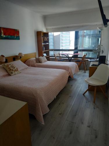 Duas camas num quarto com uma janela grande em Departamento en Apart hotel, Excelente ubicación en Microcentro em Buenos Aires