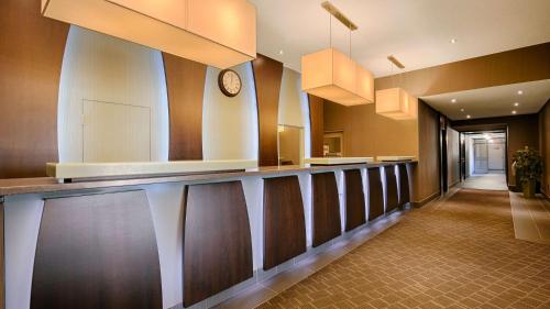 a lobby with a bar with a clock on the wall at Best Western Plus Guildwood Inn in Sarnia