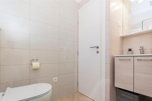 een witte badkamer met een toilet en een wastafel bij Deluxe apartment White Angel in Duće