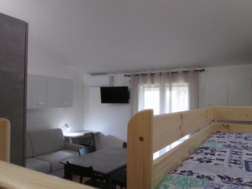 Habitación con cama, sofá y mesa. en Appartamento con Piscina in Lunigiana en Arpiola