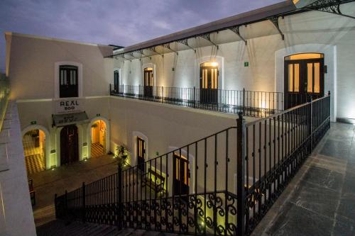 a large white building with a balcony at night at Hotel Business Real 500 in Puebla