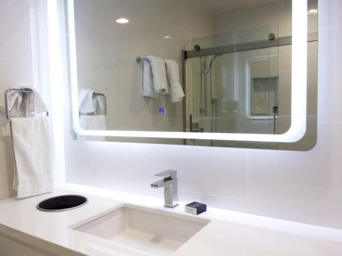 a white bathroom with a sink and a mirror at Sands Of La Jolla in San Diego