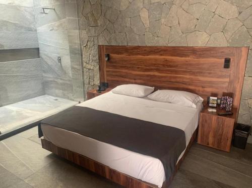 a bedroom with a large bed and a shower at Motel Rokka in Guadalajara