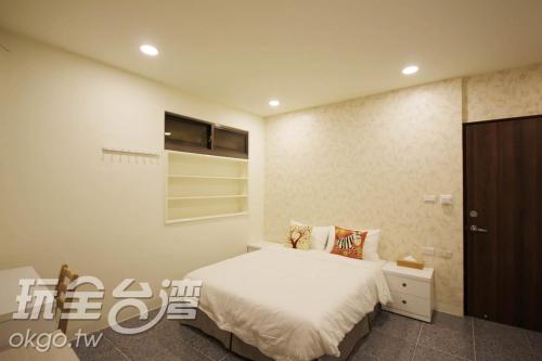 sypialnia z łóżkiem i telewizorem na ścianie w obiekcie Water Source Coffee Homestay w mieście Beigang