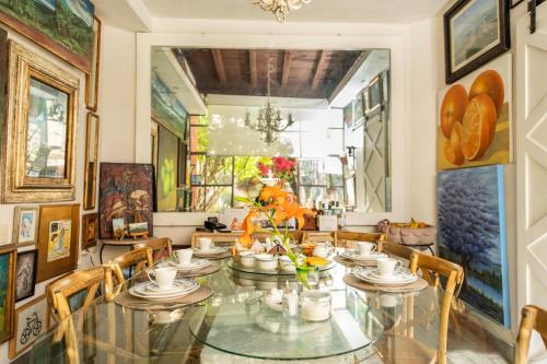 a dining room with a glass table and chairs at Casa De La O in San Miguel de Allende
