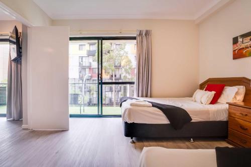 een slaapkamer met een bed en een groot raam bij 4 So Much More Family Apt 2br Parking in Perth