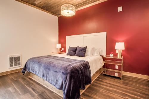 a bedroom with a large bed and a red wall at The Port of Prescott Boutique Hotel in Prescott