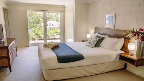 a bedroom with a large bed and a window at McMillans of Metung Coastal Resort in Metung