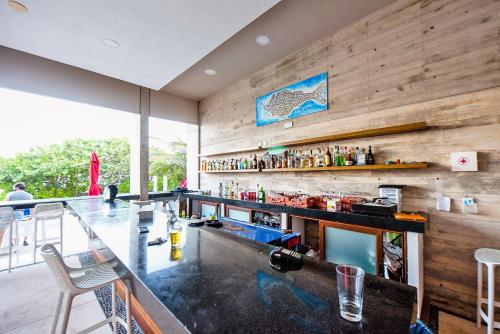 a bar in a restaurant with a wooden wall at Tao Ocean Luxury Home Akumal in Akumal