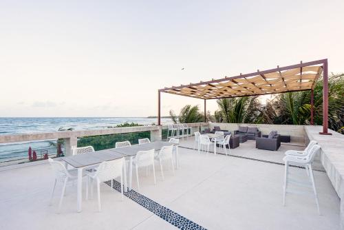 a patio with a table and chairs and the ocean at Tao Ocean Luxury Home Akumal in Akumal