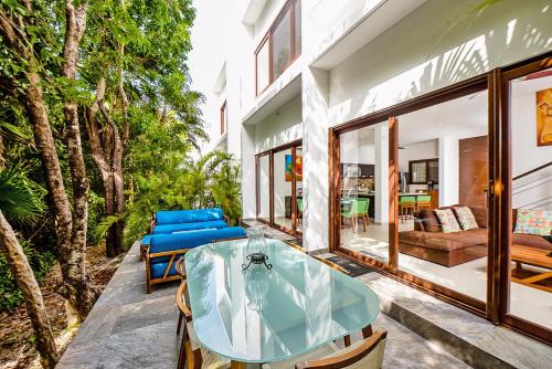 a glass table and chairs on a patio at Tao Ocean Luxury Home Akumal in Akumal
