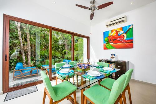 a dining room with a glass table and chairs at Tao Ocean Luxury Home Akumal in Akumal