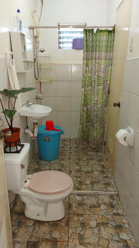 y baño con aseo, lavabo y ducha. en Island samal overlooking view house with swimming pools en San Antonio