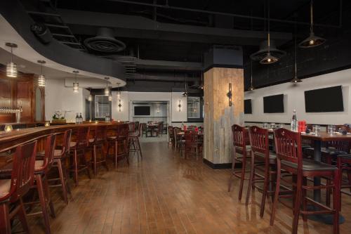 a bar in a restaurant with wooden tables and chairs at Crowne Plaza Crystal City-Washington, D.C. by IHG in Arlington