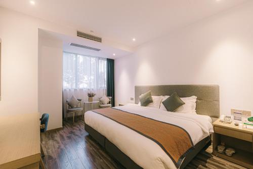 a bedroom with a large bed and a window at Shanghai JOYFUL YARD Hotel-Free shuttle bus to Pudong Airport and Disneyland in Shanghai