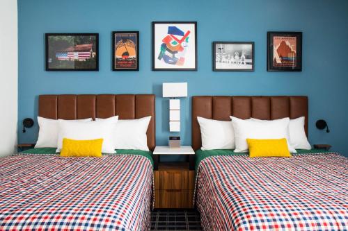 Uptown Suites Extended Stay Miami FL – Homestead في هومستيد: سريرين في غرفة بجدران زرقاء
