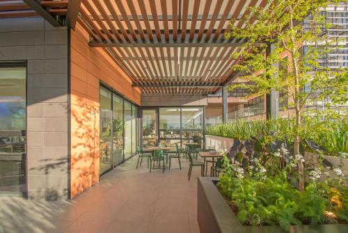 an office lobby with tables and chairs and plants at Staybridge Suites - Guadalajara Novena by IHG in Guadalajara