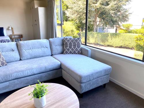 a living room with a blue couch and a table at Alpine Lake Motel in Taupo