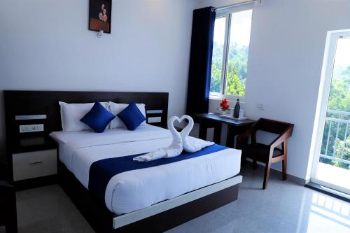 a bedroom with a bed with a swan towel on it at Casillda Munnar in Munnar
