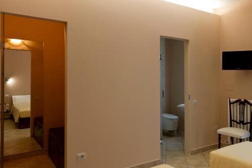 a room with a bathroom and a bedroom with a toilet at B&B Aquisgrana in Corridonia