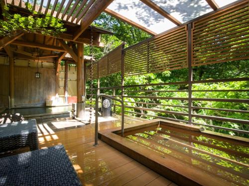 an outdoor deck with a pergola and a clock at Jizaiso in Nasu