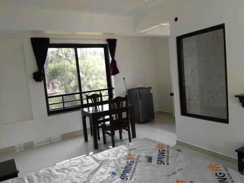 a room with a table and chairs and a window at Wave Morjim Hotel in Morjim