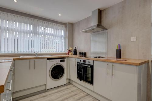 uma cozinha com máquina de lavar e secar roupa em Sunderland Self Catering 4 - City Centre Townhouse with free parking em Sunderland