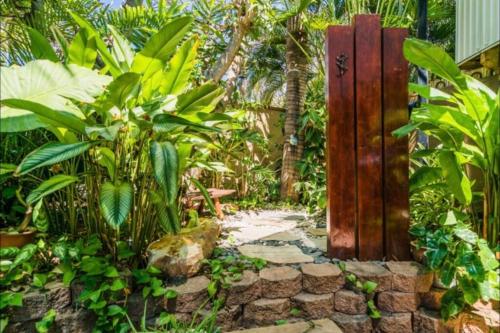 a wooden door in the middle of a garden at Elevated Tropical House in Casuarina