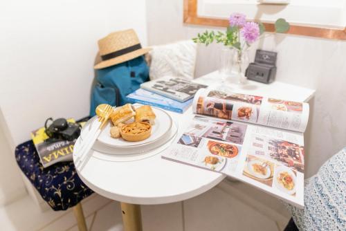 a white table with a plate of food on it at Casa Blanca Guesthouse in Nagasaki