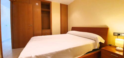 デニアにあるSueño de Denia III VAC006 Denirentの白いベッドと木製キャビネット付きのベッドルーム1室が備わります。